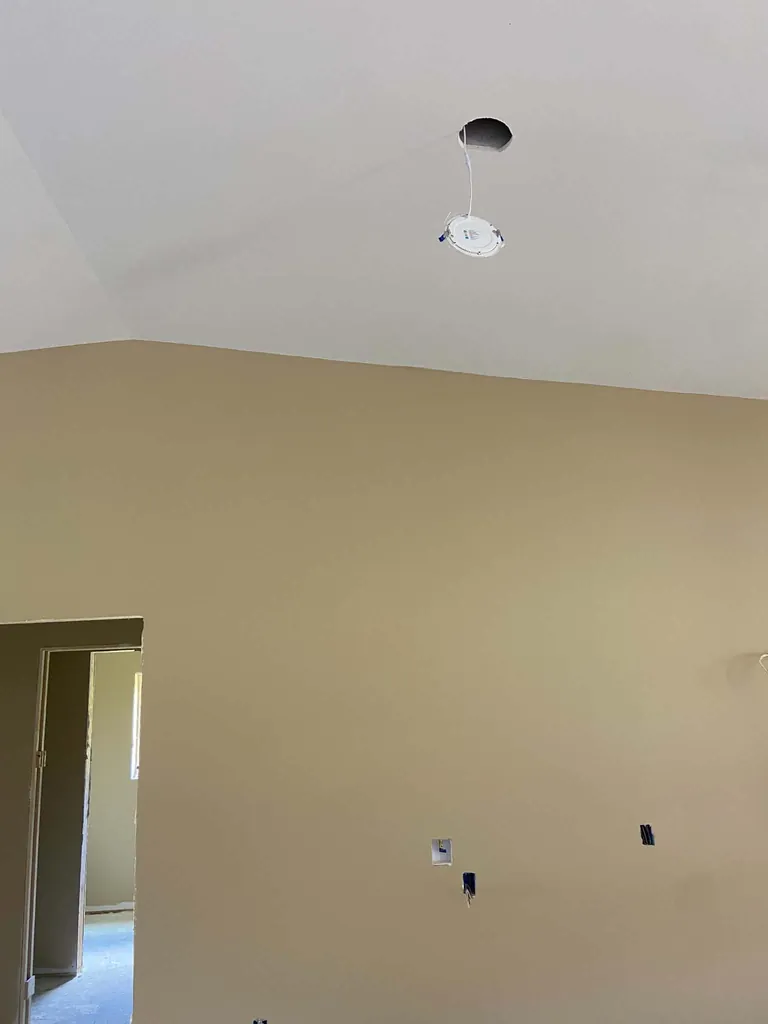 Vaulted ceiling finished in white above a smooth painted wall